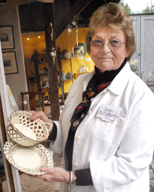 Jane McClafferty, New Canaan, Conn., holds a piece of reticulated English creamware, circa 1800, hand painted with passion flower decoration.